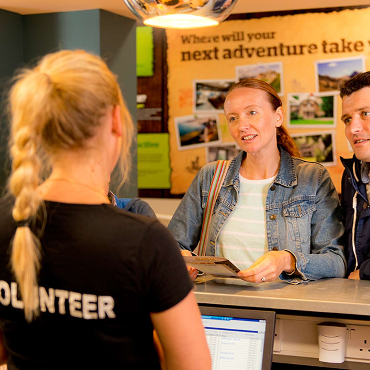 Volunteer receptionist checking in guests at a hostel