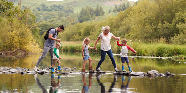 Family stepping on stones in a lake
