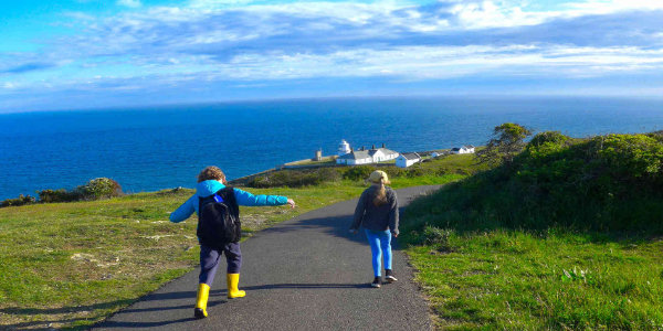 Children walking near a lighthouse