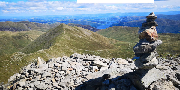 Stack Of Rocks On Helvellyn Summit With Landscape Against Sky