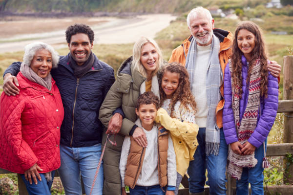 Family and friends taking a photo with a beach in the background